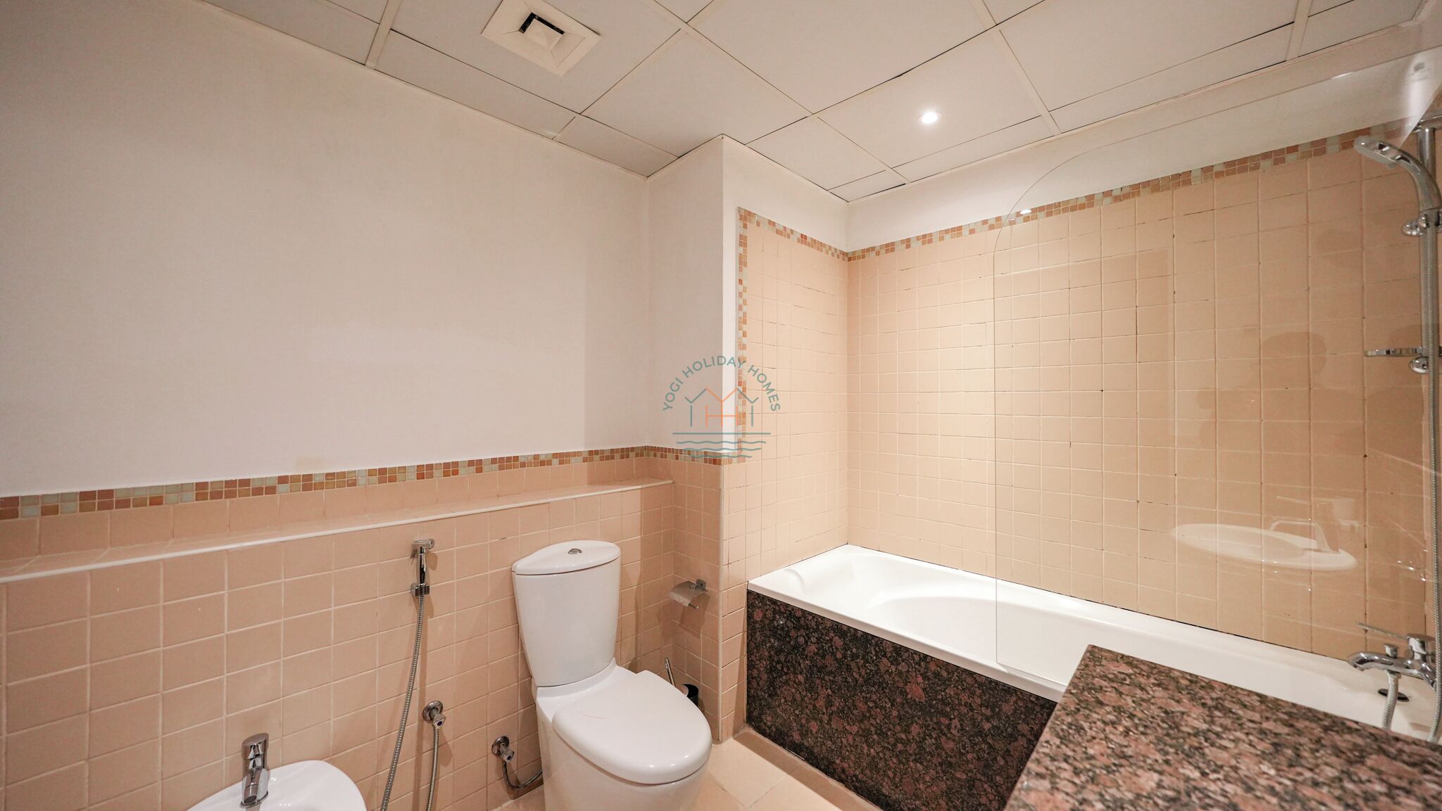 A bathroom with a toilet, sink, and bathtub.