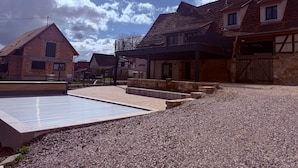 A residential area with houses, a paved driveway, and a gravel area. - La Grange - at the Ancienne ferme (Steinseltz)