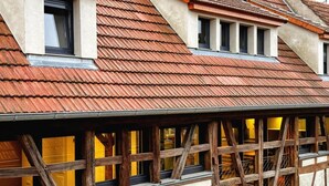 A traditional half-timbered building with a sloped roof and multiple windows. - L'Étable - at the Ancienne ferme (Steinseltz)