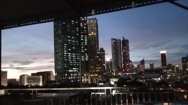 Lo skyline di una città al crepuscolo, con edifici illuminati.