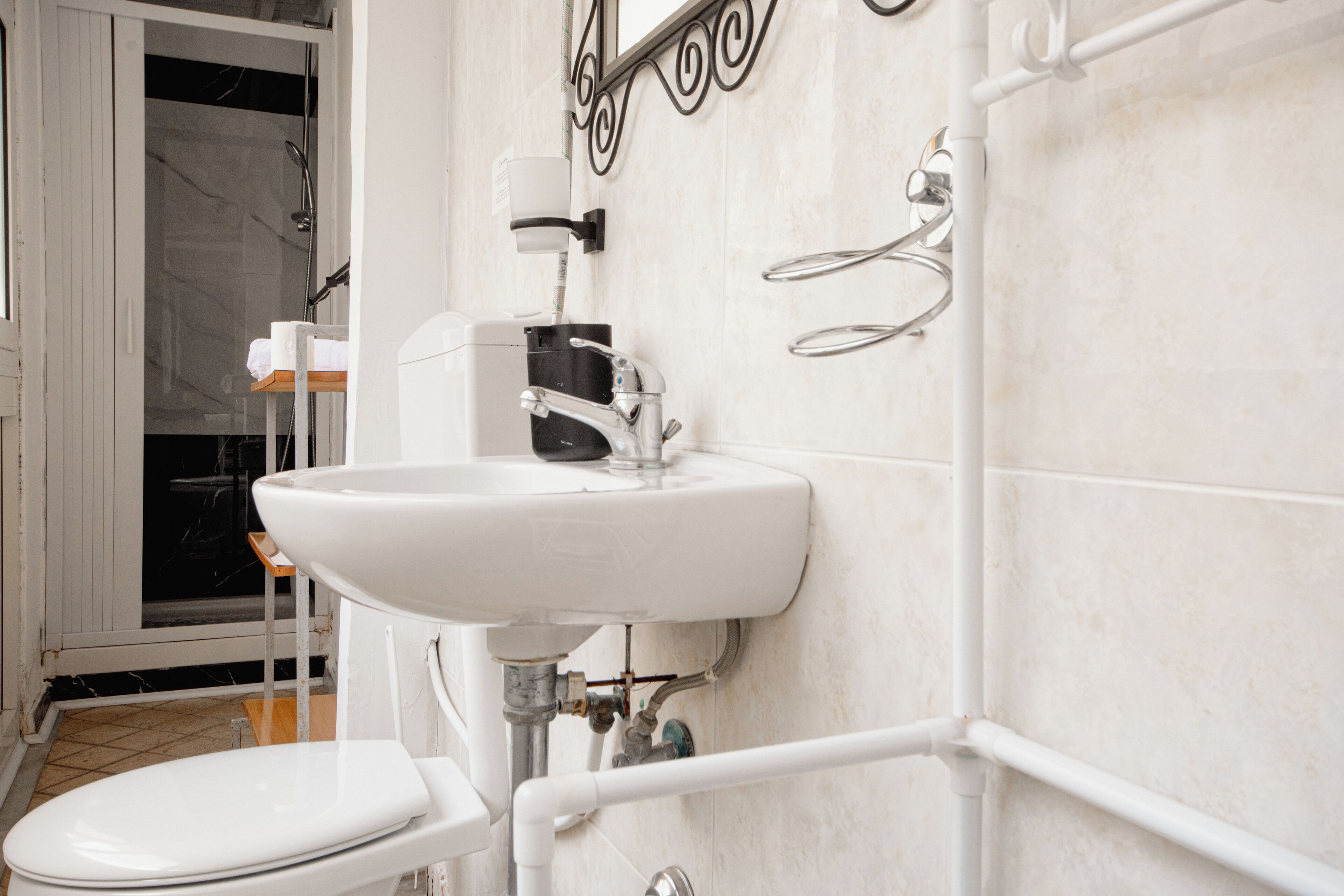 A bathroom with a white sink, toilet, and shower area.