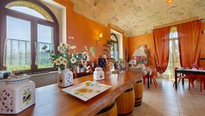 Cucina con un piano di lavoro in legno, zona pranzo con sedie rosse e vista dalla finestra.