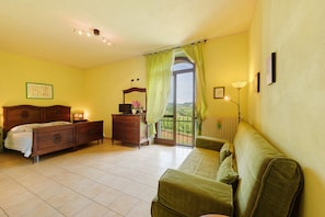 A bedroom with a bed, dresser, and a green sofa.