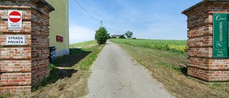 Une voie privée menant à un bâtiment sur lequel on peut voir une pancarte indiquant « Strada Privata », une autre indiquant « Divieto di Accesso » et une troisième indiquant « Ferruti ».