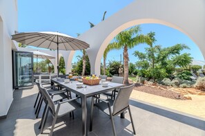 An outdoor dining area with a table, chairs, and a large umbrella.