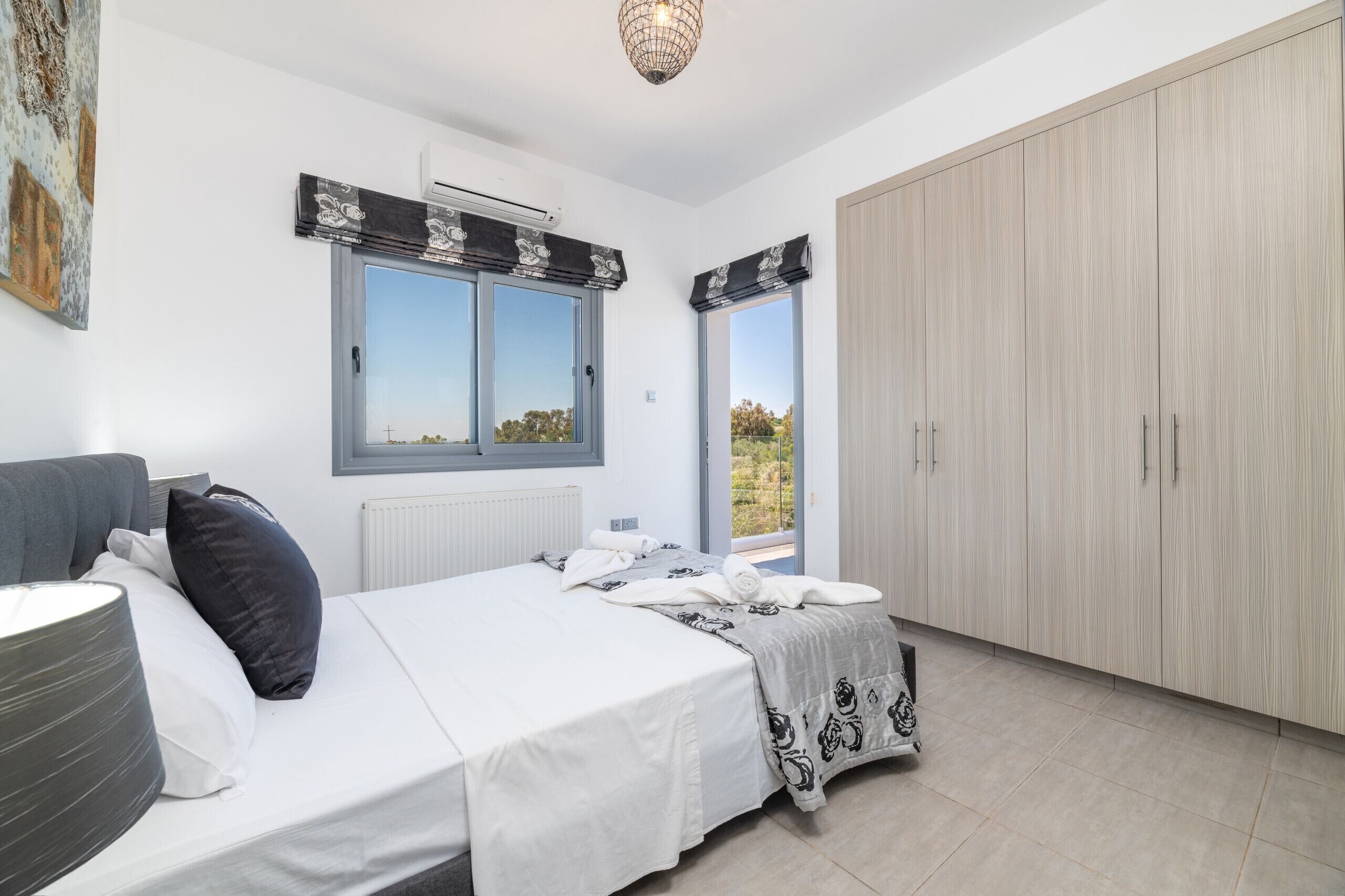 Una camera da letto con un letto, un armadio, un termosifone e una finestra con vista.