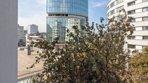 A modern building with a curved glass facade, surrounded by other buildings and a tree. - Apartment 'Destiny Oporto' with Wi-Fi (Maia)