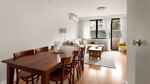 Una sala moderna con una mesa de comedor y sillas, un sofá y un sillón amarillo.