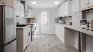 Een moderne keuken met witte kasten, roestvrijstalen apparatuur en een centraal eiland.