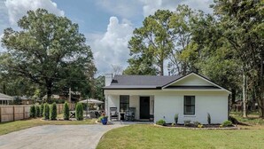 A single-story house with a front porch, a driveway, and a well-maintained lawn.