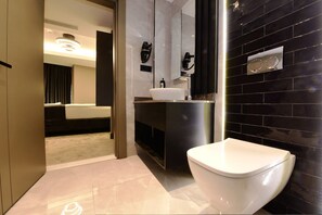 A modern bathroom with a white toilet, a sink, and a mirror. - Mery Hotel Istanbul (Istanbul)