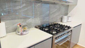 Una cocina moderna con estufa a gas, cafetera y dispensador de toallas de papel.