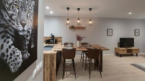 A modern kitchen with a wooden island, pendant lights, and a dining area with a wooden table and chairs. - B As in... Forest walk (Saint-Amand-les-Eaux)
