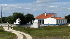 Un bâtiment avec un toit rouge, des murs blancs et un panneau solaire.