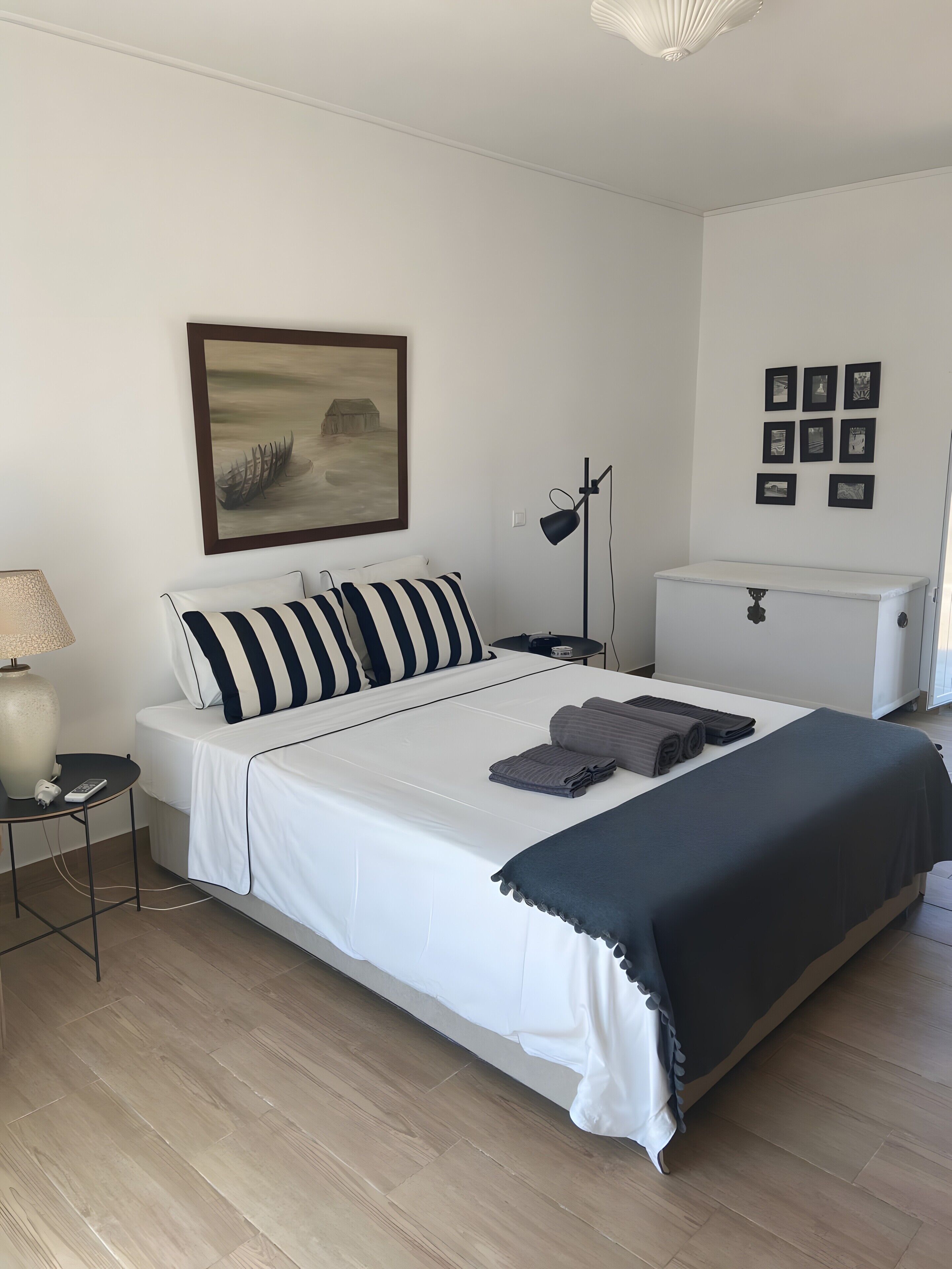 Une chambre à coucher bien rangée, avec un lit, une table de chevet, une lampe et un radiateur.