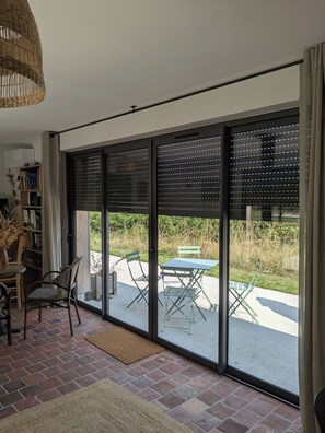 Une pièce dotée d’une porte-fenêtre coulissante donnant sur un patio extérieur.