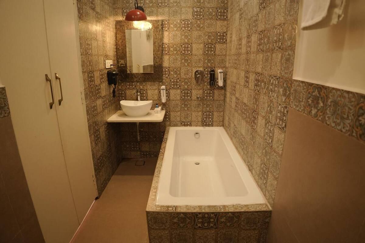 A bathroom with a bathtub, a sink, and a mirror.