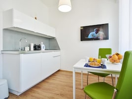 Een moderne keuken met witte kasten, een inbouwfornuis en een ontbijt klaar dektafel.