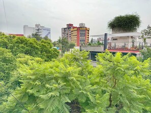 A building with a red roof and a green garden in the foreground. - Departamento en Condesa (Mexico City)
