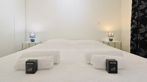 A hotel room with a large bed, two bedside tables with lamps, and two welcome boxes. - Le Suquet - 2 bedroom - terrace (Cannes)