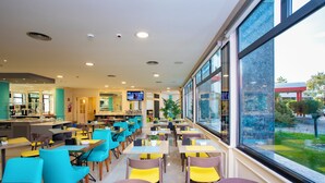 Un restaurant moderne doté d’un long comptoir, de nombreuses tables et de chaises.