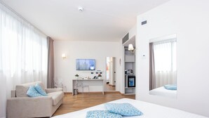 Une chambre d’hôtel moderne équipée d’un lit, d’un canapé, d’un bureau et d’une télévision.