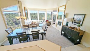 A dining area with a glass table and chairs, a sofa, and a fireplace. - River Ridge 328A Ground Floor Condo in Bend, OR 1 Bd, 1 Ba 328A (Bend)