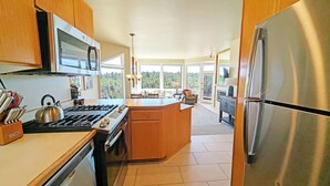 A modern kitchen with a central island, stainless steel appliances, and a view of the outdoors. - River Ridge 328A Ground Floor Condo in Bend, OR 1 Bd, 1 Ba 328A (Bend)