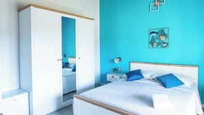 Un dormitorio con cama, armario, mesita de noche y un adorno en la pared.
