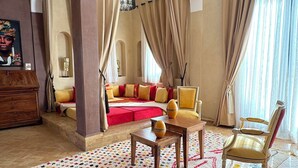 A spacious living room with a red sofa, a wooden coffee table, and a yellow armchair.