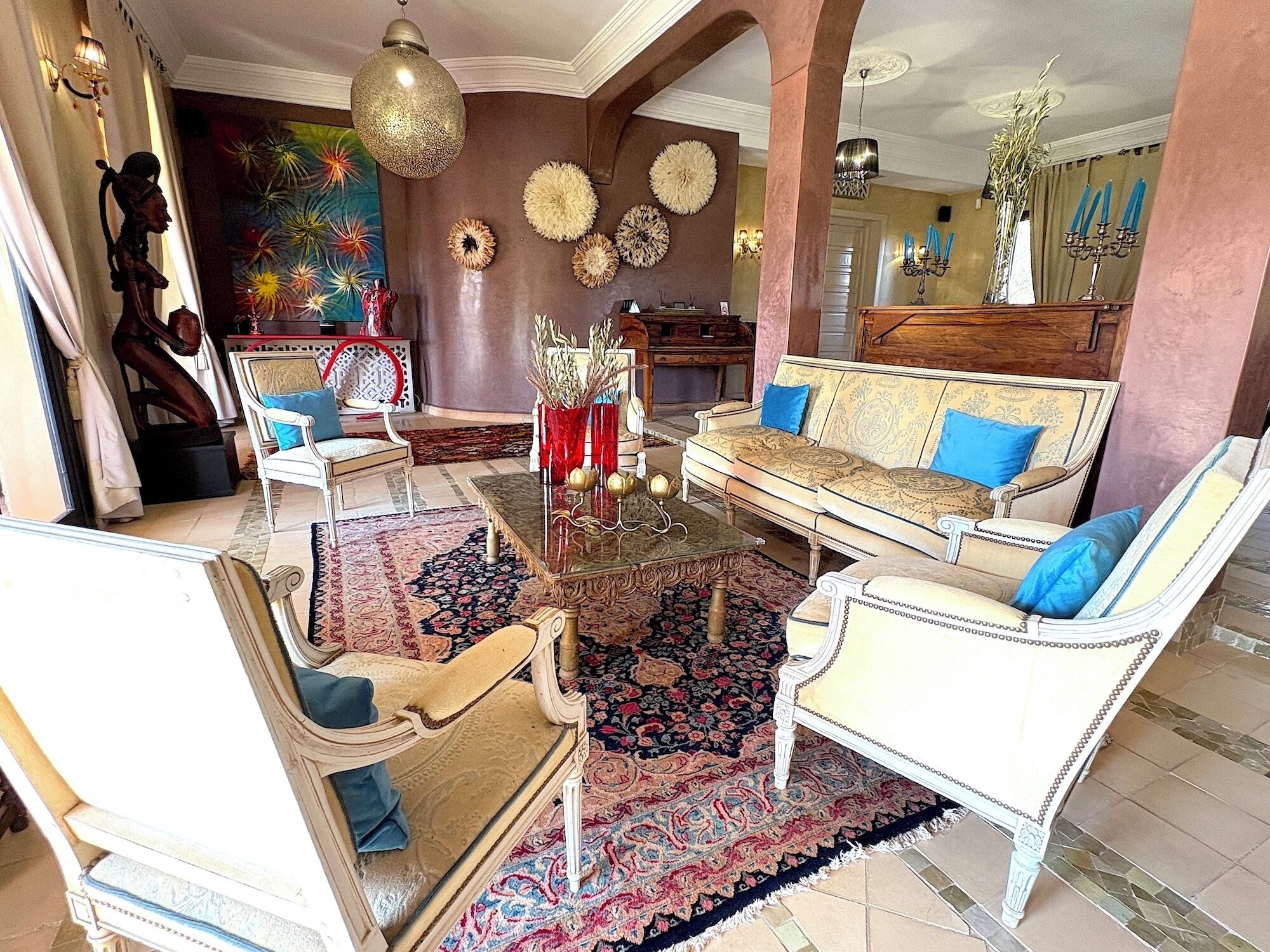 A spacious living room with a large sofa, two armchairs, a coffee table, and a decorative rug.