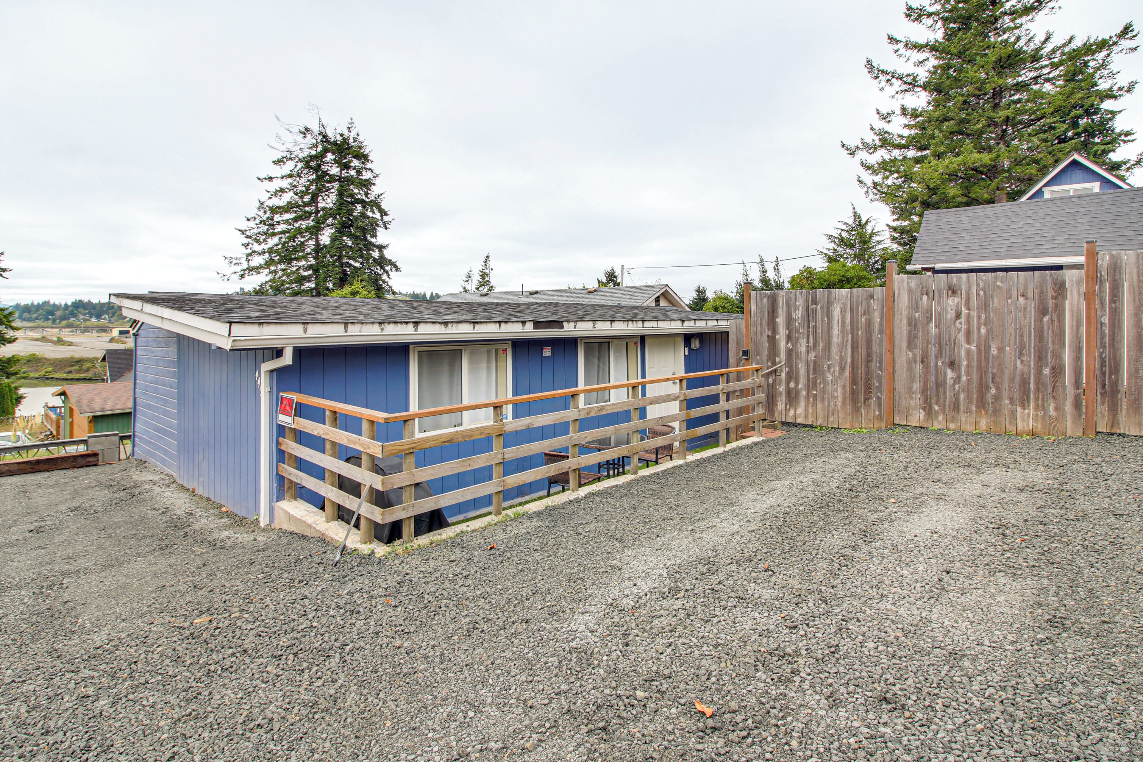 A small, single-story building with a blue exterior and a wooden fence.