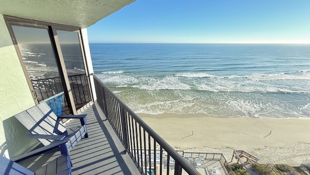 Ein Balkon mit Blick auf den Ozean und den Strand.