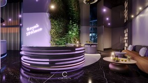A modern interior with a central circular platform displaying 'Royal SPA Palace' and a lush vertical garden. - Royal Palace Hotel & Spa (Kirrwiller-Bosselhausen)