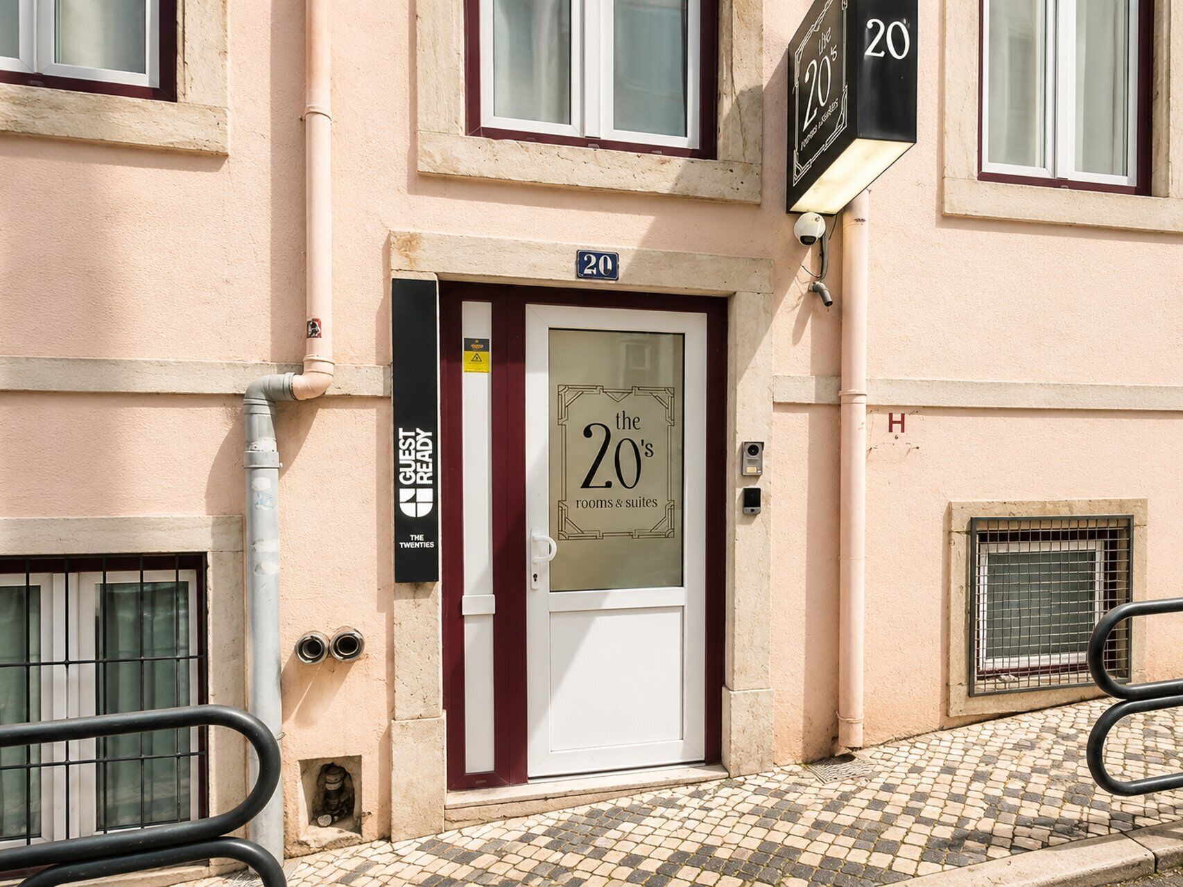 A building entrance with a door labeled 'The 20's' and a sign indicating '20' above.