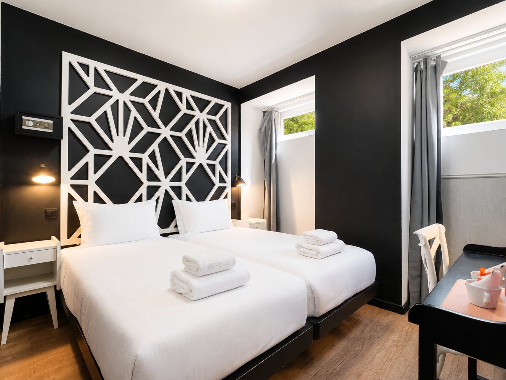 Une chambre d’hôtel avec deux lits, un bureau et une chaise.