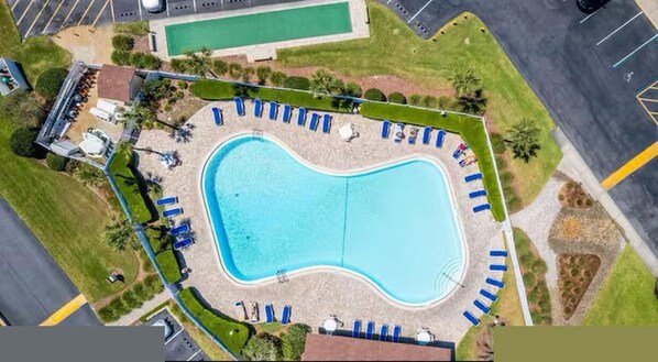 An aerial view of a swimming pool surrounded by lounge chairs and a small building. -  Escape with Private Beach Access & Coastal Charm (St. Augustine)