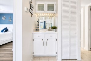 A white bathroom with a vanity, a mirror, and a window.