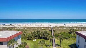 A beachfront property with two buildings, a paved walkway, and a parking area. -  Escape with Private Beach Access & Coastal Charm (St. Augustine)