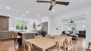 Une cuisine spacieuse avec un îlot central, une table à manger en bois et des chaises.