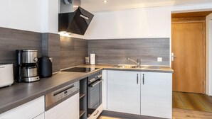 Una cocina moderna equipada con lavavajillas, horno y cafetera.