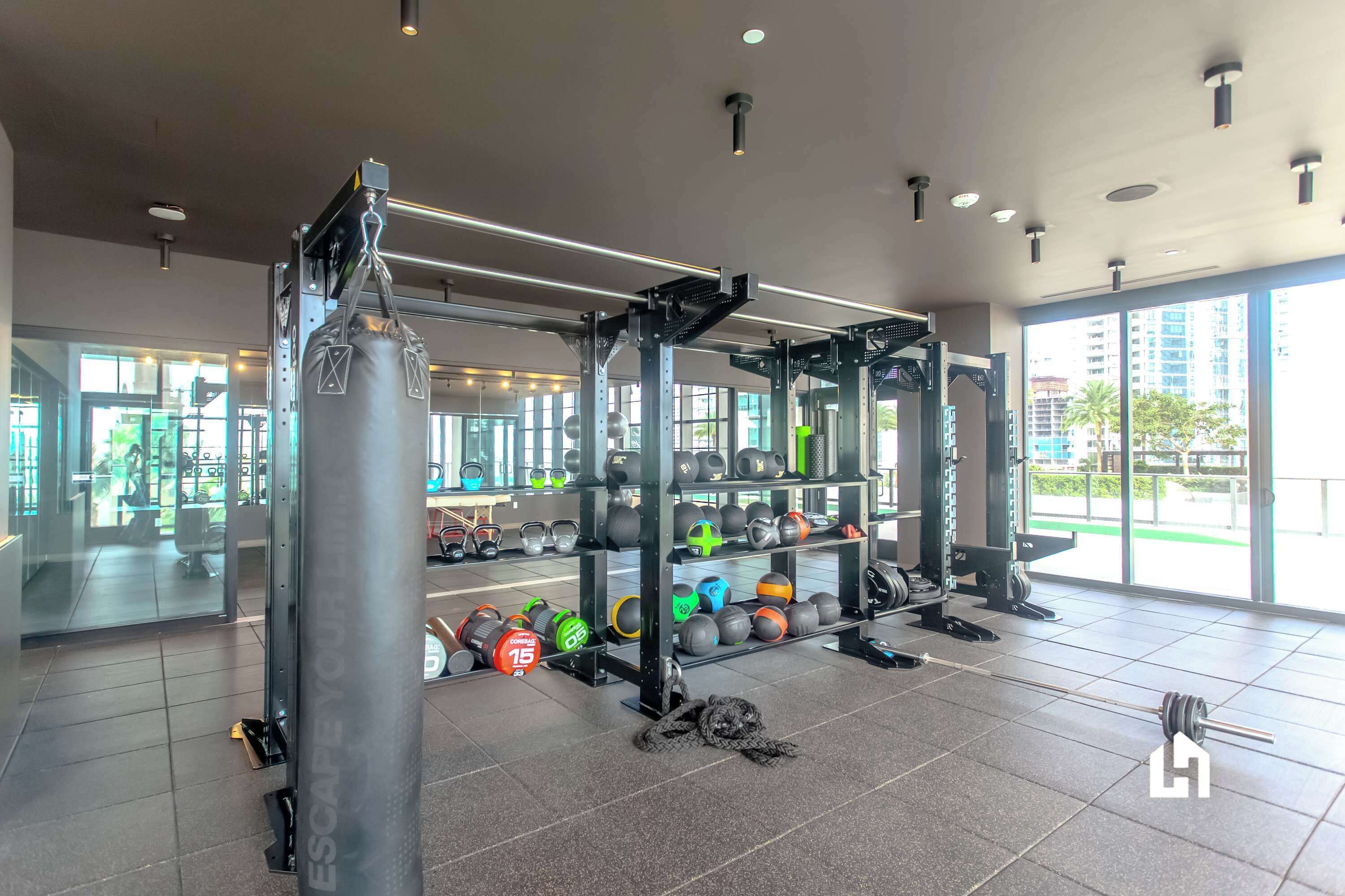 A modern gym with weightlifting equipment, a squat rack, and a variety of weights.
