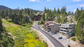 Une station de montagne comprenant plusieurs bâtiments, une route sinueuse et un espace de stationnement.