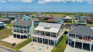 A coastal residential area with multiple two-story houses featuring balconies and waterfront views. - Casa Del Sol 4 Bedroom Home (Port Bolivar)