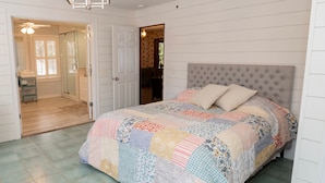 A bedroom with a large bed, a chandelier, and a view of a bathroom and dining area. - 371 Mountain Hill Rd, Fortson (Harris County)
