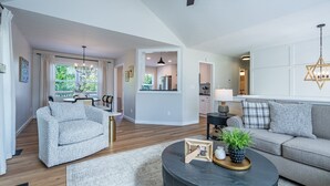 A spacious living area with a sofa, a round coffee table, and a dining area with chairs. - 18 Huntcliff Dr, Cartersville (Cartersville)