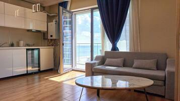 Deluxe Apartment, Balcony, Partial Sea View | Living area | 110-cm flat-screen TV with cable channels