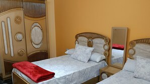 A hotel room with two beds, a wardrobe, and a mirror. - THE MESSAHA ROYALE (Giza Governorate)