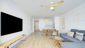 A modern living room with a flat-screen TV, a ceiling fan, a dining area with chairs and a table, and a sofa with cushions. - Ref. 585392 (Motril)
