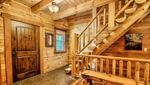Ein Holzinnenraum mit Treppe, Holztüren und einem Fenster.
